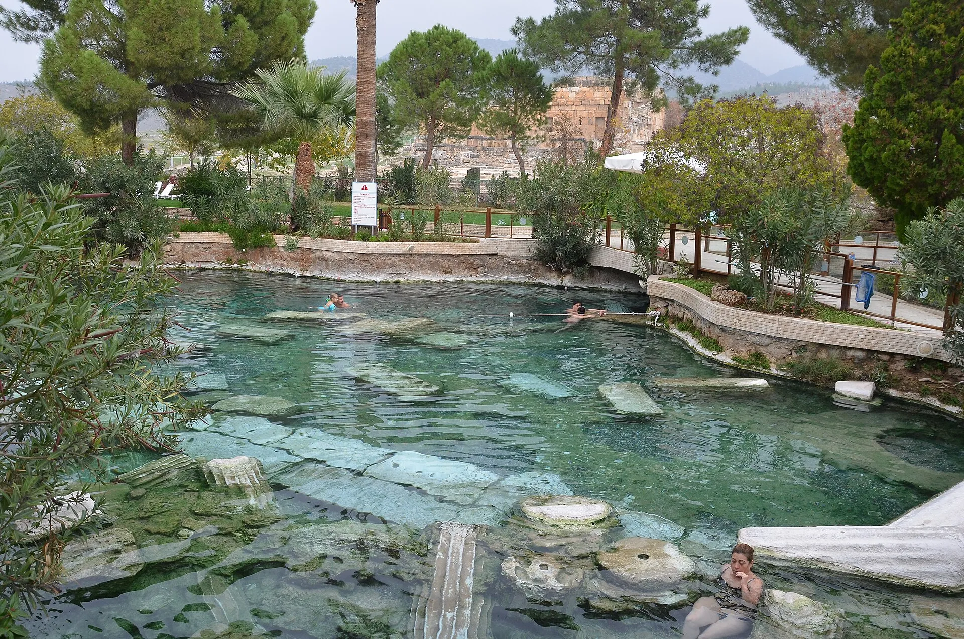 Swimmers floating over sunken Roman columns in the warm blue water of Cleopatra's Antique Pool