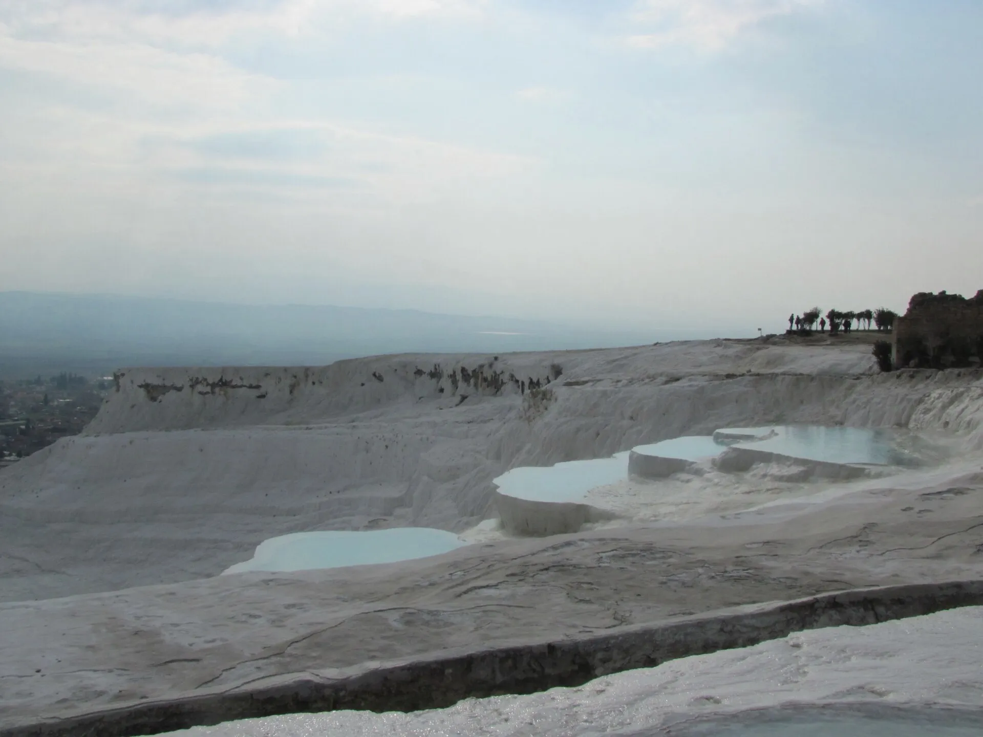 The still, glassy thermal pools on the white travertine terraces of Pamukkale