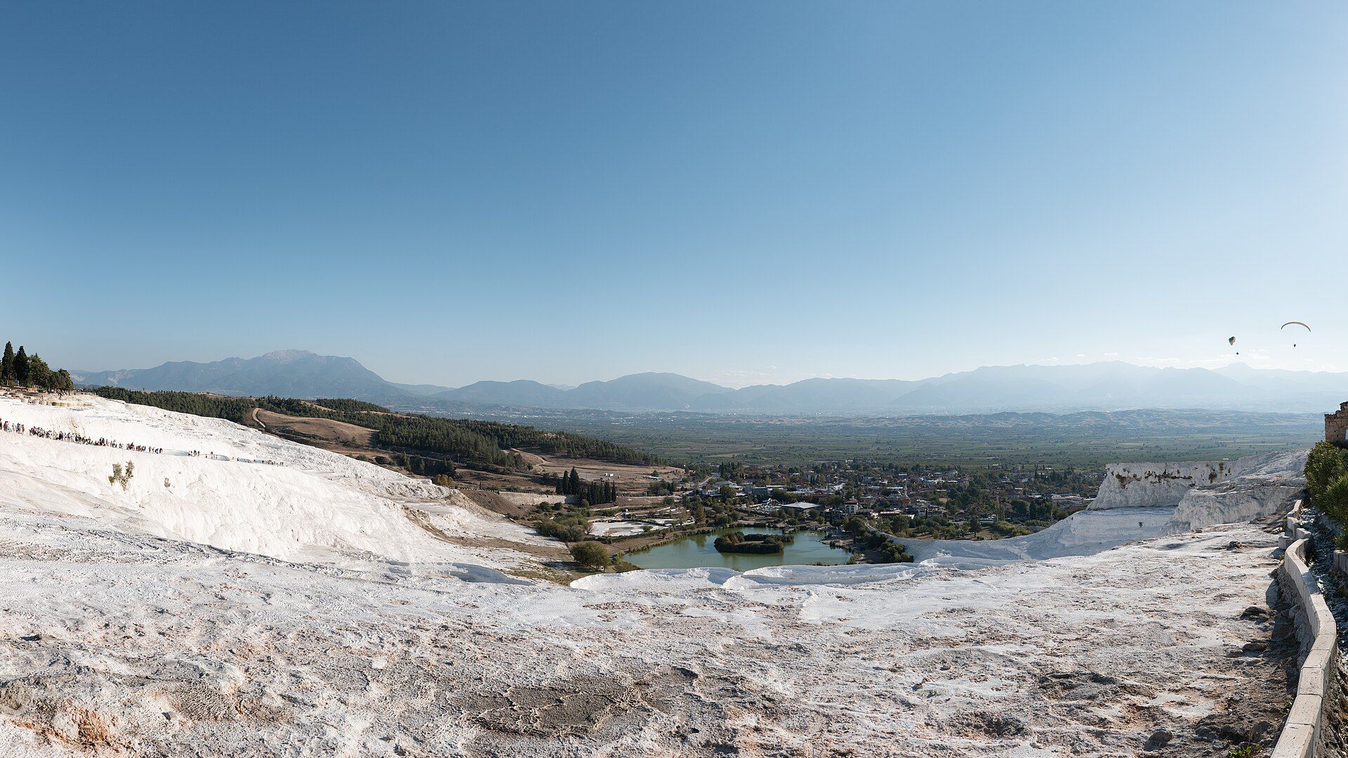 Visitors walking the white travertine terraces of Pamukkale