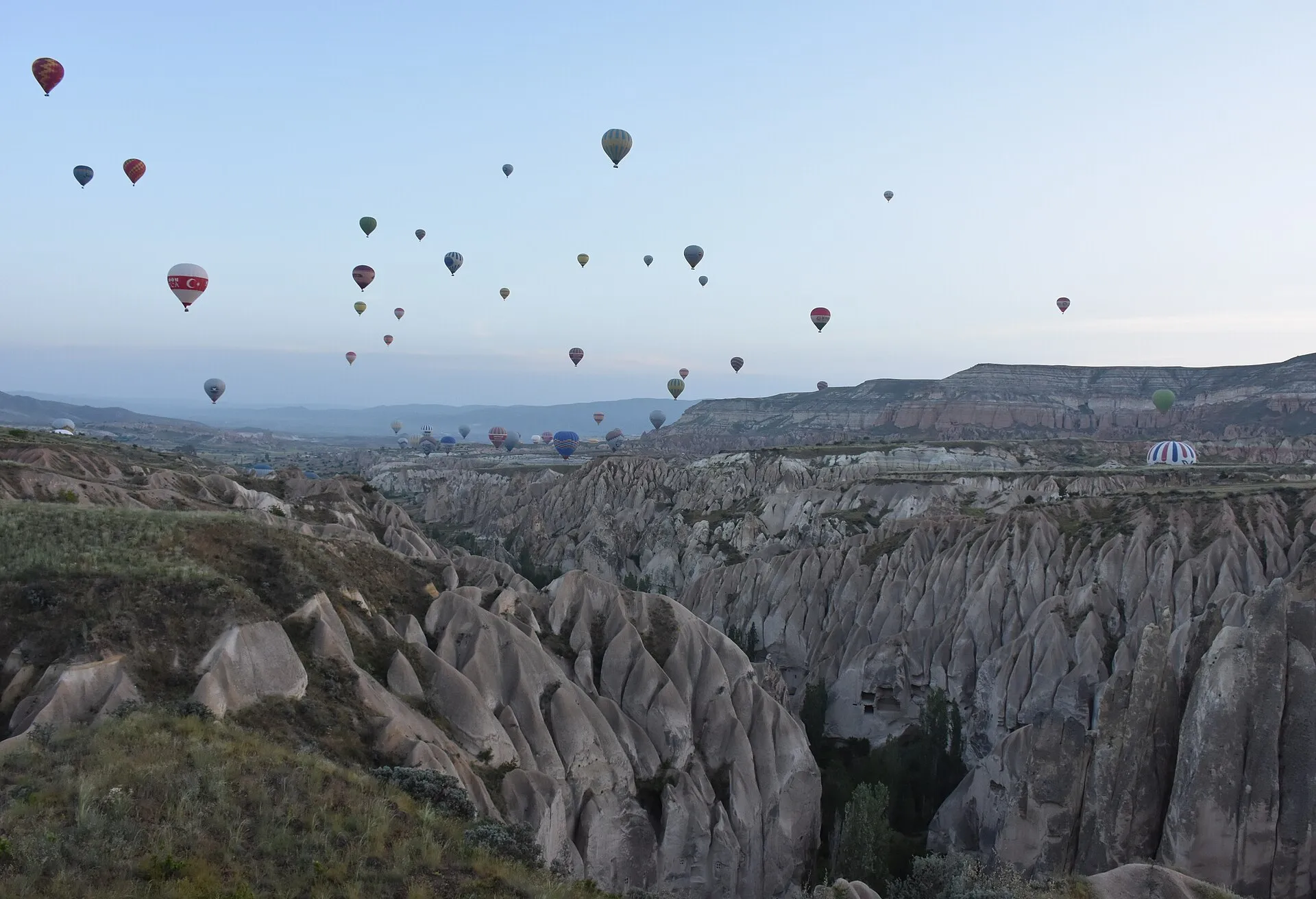 Hot-air balloons at sunrise over Cappadocia fairy-chimney valleys near Göreme